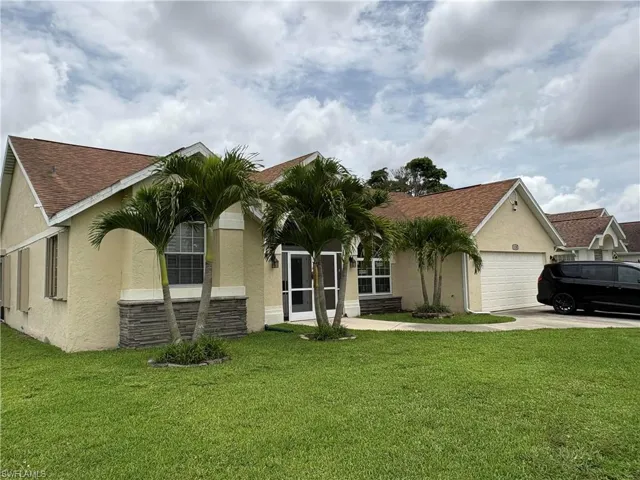 View of front of home with an attached garage, stucco siding, concrete driveway, and a front yard