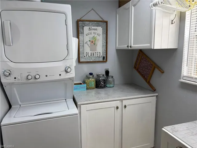Laundry area with stacked washer / dryer and cabinet space