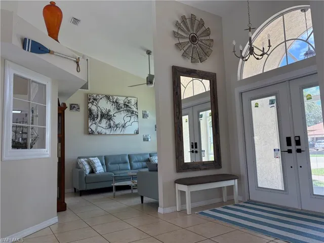 Entryway featuring french doors, a high ceiling, and light tile patterned floors