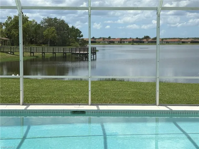 Outdoor pool featuring a water view and a lawn