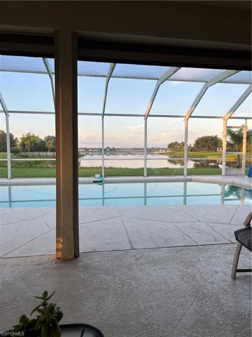 Pool at dusk featuring an outdoor pool and glass enclosure