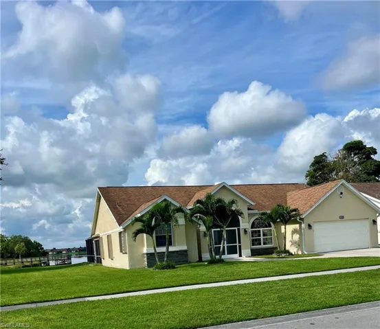 Single story home with stucco siding, a front yard, driveway, an attached garage, and a shingled roof