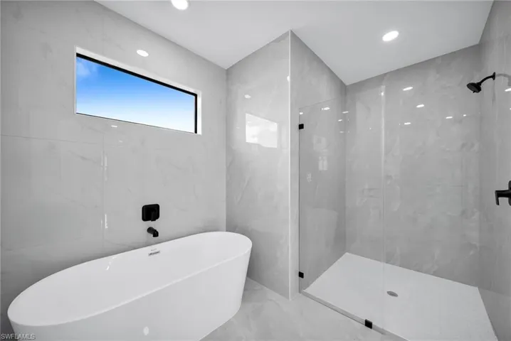 Bathroom with separate shower and tub and tile walls