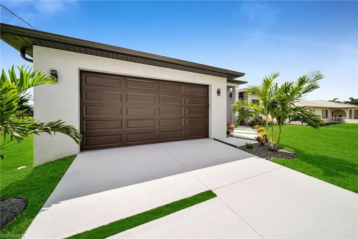 Garage featuring a lawn