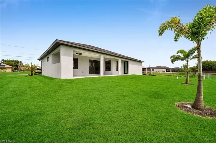 Back of property featuring a lawn and a patio