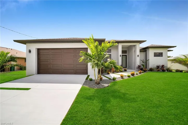 View of front facade with a front yard and a garage