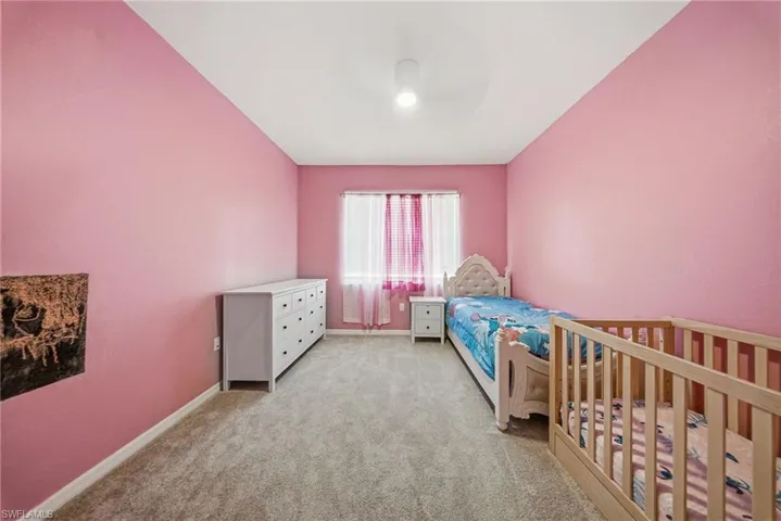 Bedroom featuring light carpet and a ceiling fan