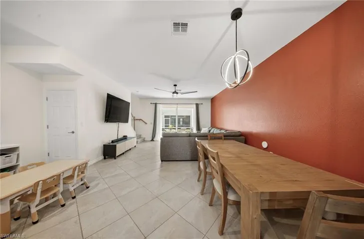 Dining space with light tile patterned floors and a ceiling fan
