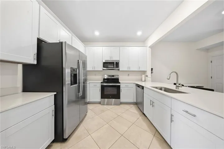 Kitchen featuring stainless steel appliances, white cabinetry, recessed lighting, and light tile patterned floors