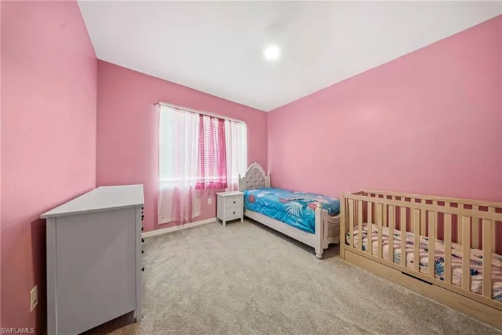 Bedroom with light carpet and baseboards
