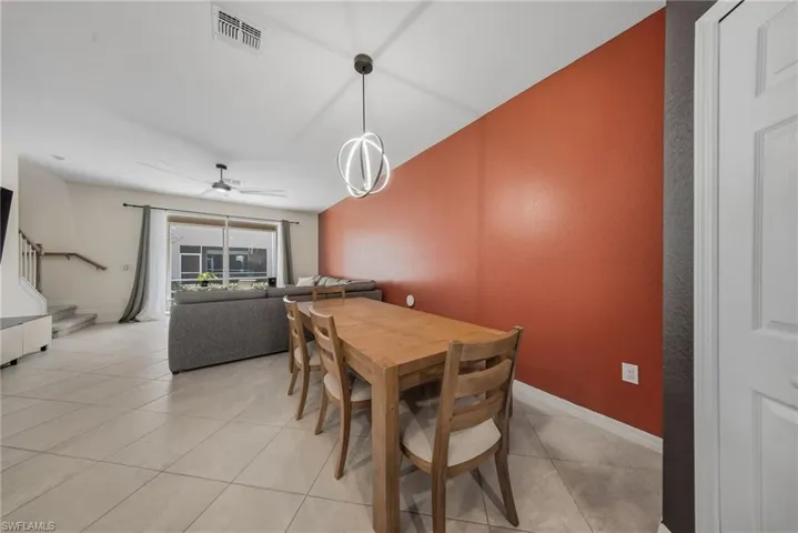 Dining area featuring light tile patterned floors and a ceiling fan