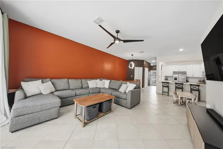 Living area with a ceiling fan and light tile patterned floors