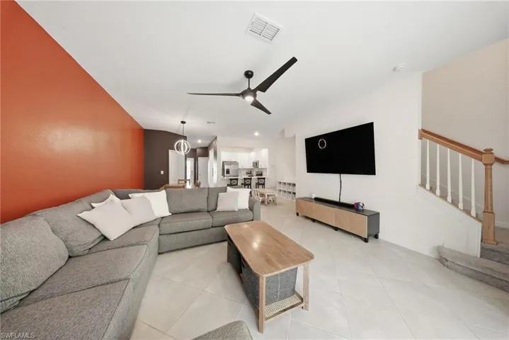 Living area with ceiling fan and light tile patterned flooring