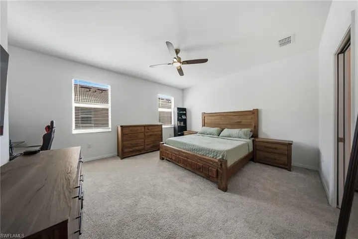 Bedroom featuring light colored carpet and ceiling fan