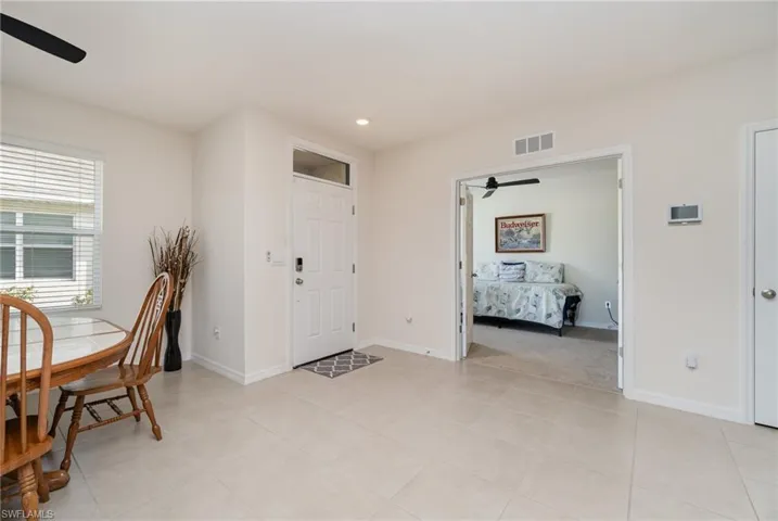 Entryway featuring light tile patterned floors and ceiling fan