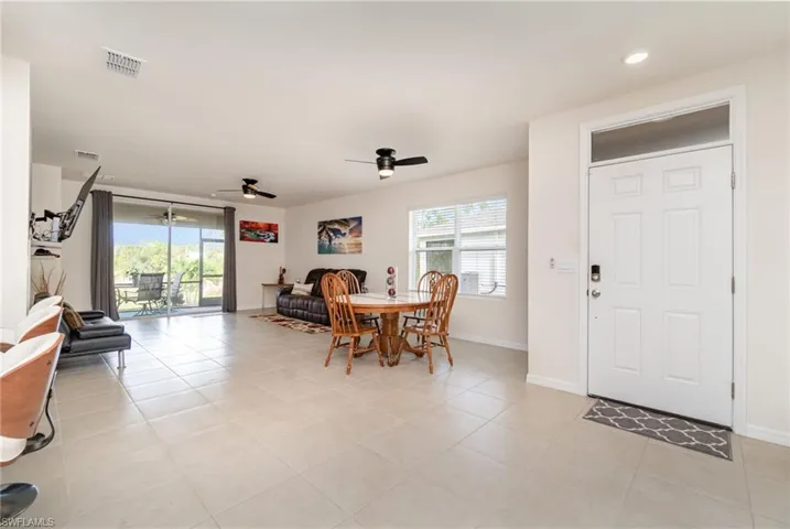 Dining room with ceiling fan, light tile patterned floors, and a wealth of natural light
