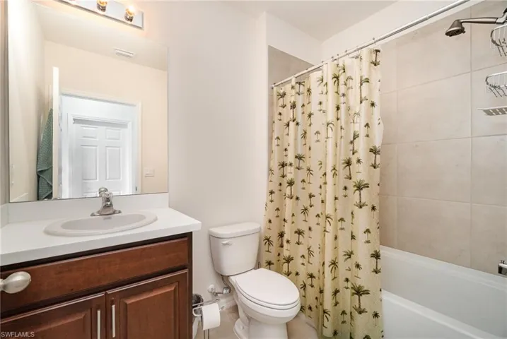 Full bathroom with vanity, toilet, and shower / bathtub combination with curtain