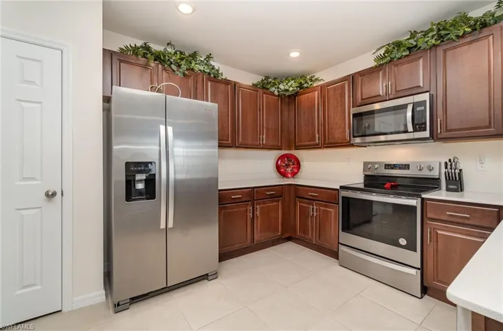 Kitchen featuring light tile patterned flooring and appliances with stainless steel finishes