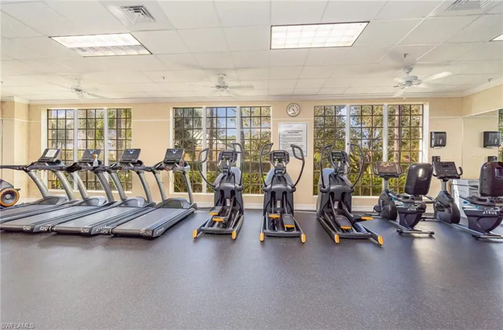 Gym featuring a paneled ceiling, ceiling fan, and ornamental molding