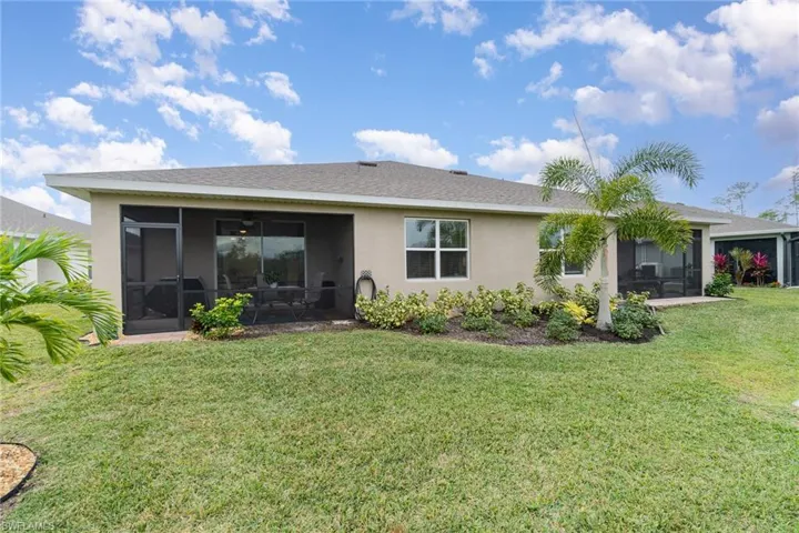 Rear view of property with a sunroom and a yard