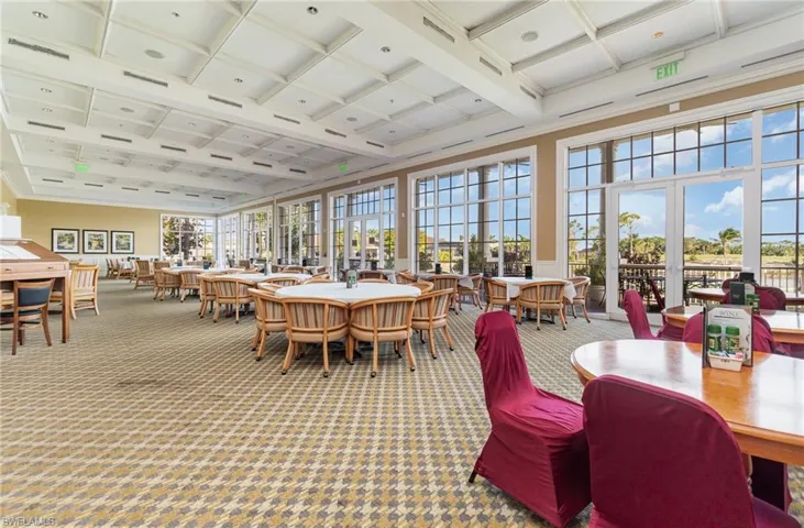 Clubhouse carpeted dining area featuring beamed ceiling and coffered ceiling