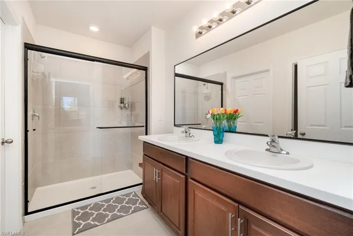 Bathroom with tile patterned floors, vanity, and walk in shower
