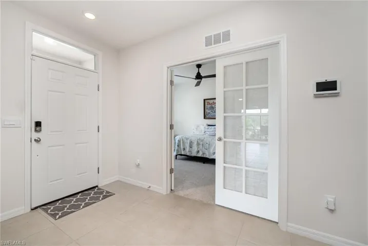 Entrance foyer with ceiling fan and light tile patterned flooring