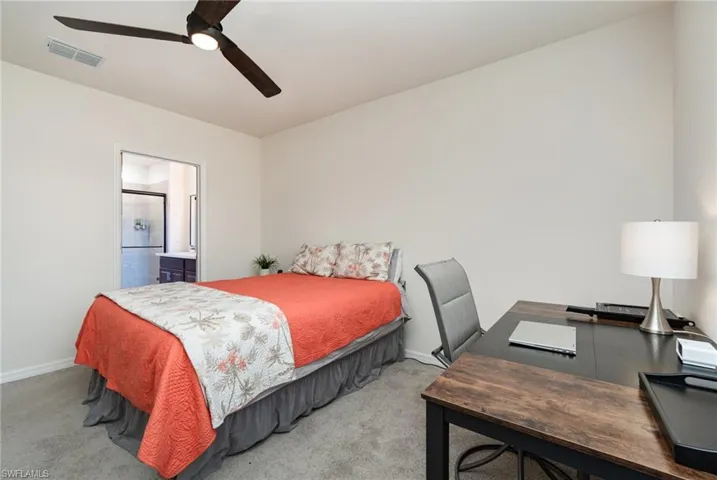 Bedroom featuring carpet flooring, connected bathroom, and ceiling fan