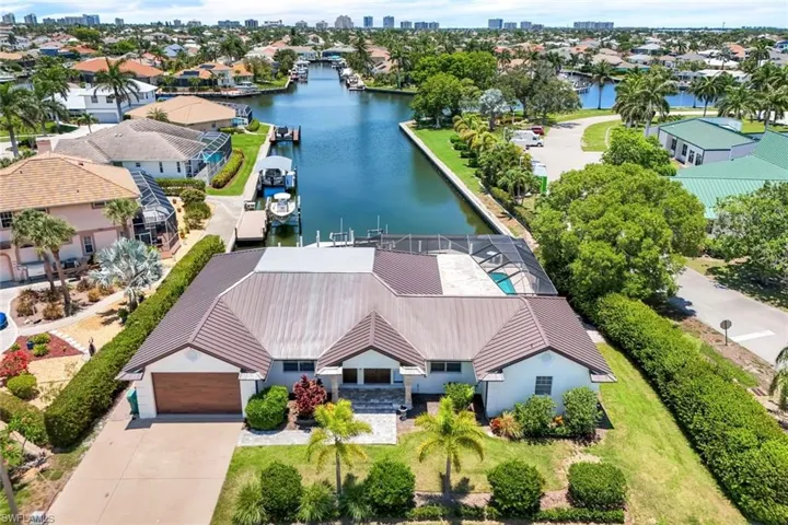 Aerial perspective of suburban area featuring a large body of water and city skyline