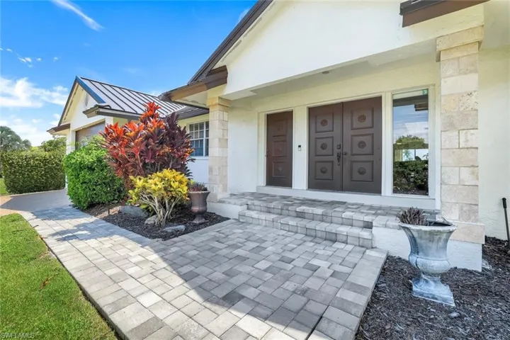 Property entrance featuring a standing seam roof and stucco siding