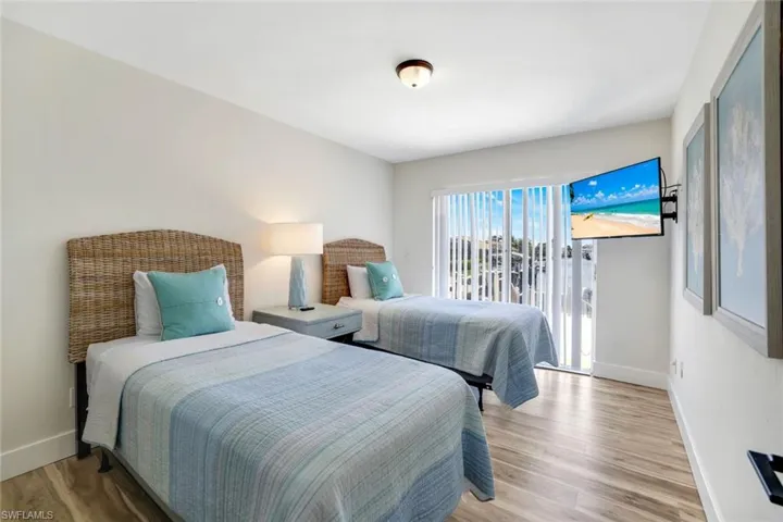 Bedroom with wood finished floors and access to exterior