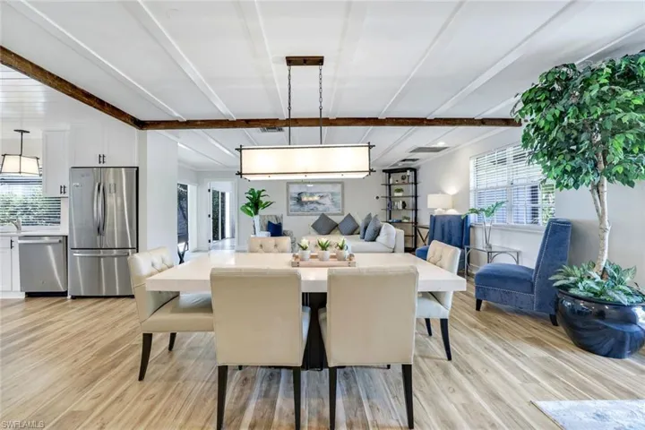 Dining area featuring light wood-type flooring, plenty of natural light, and beam ceiling