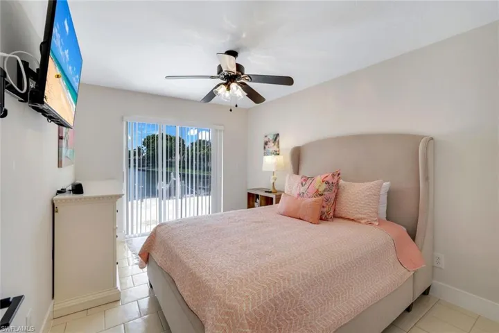 Bedroom with access to exterior, light tile patterned floors, and ceiling fan
