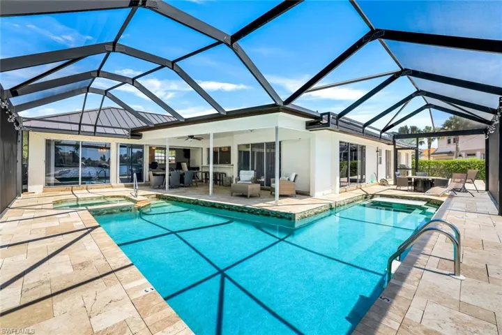 Integrated pool / hot tub featuring a sunroom, a patio area, glass enclosure, and an outdoor living / dining area