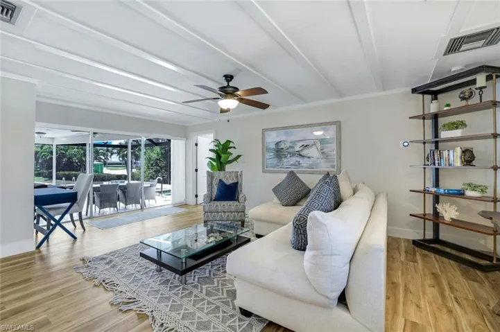 Living area featuring light wood finished floors, ceiling fan, and crown molding