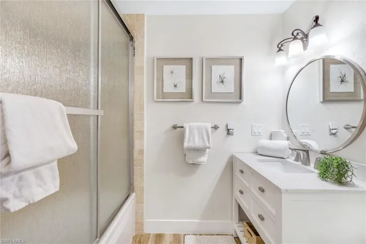 Full bath featuring vanity and combined bath / shower with glass door