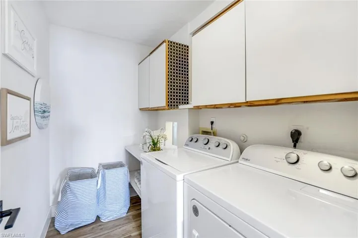 Laundry room featuring cabinet space, independent washer and dryer, and light wood-type flooring