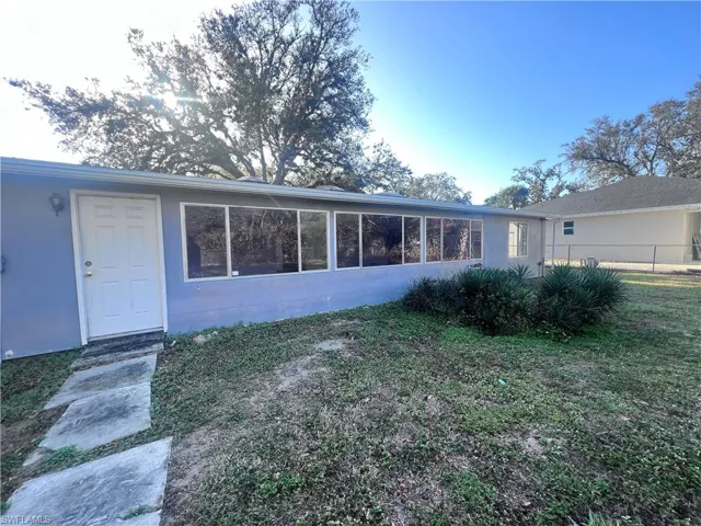 Back of house featuring a lawn and fence
