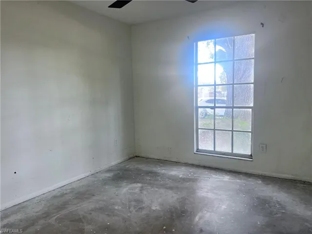 Empty room featuring unfinished concrete flooring