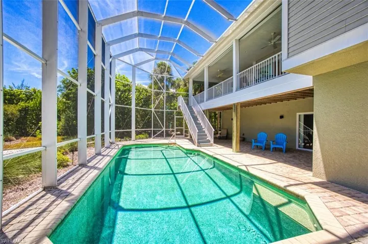 Outdoor pool featuring a ceiling fan, stairway, a patio, and a lanai