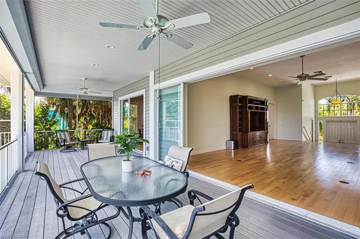 Wooden deck with a ceiling fan and outdoor dining area