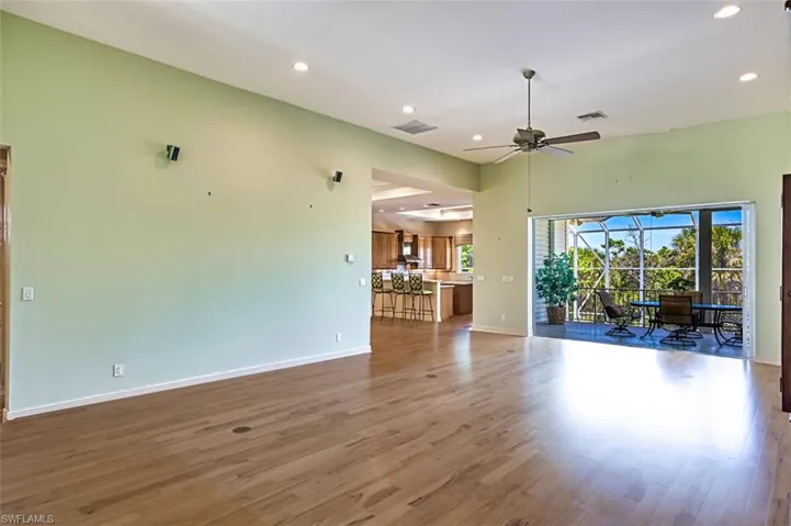 Unfurnished living room with wood finished floors, recessed lighting, ceiling fan, and a sunroom