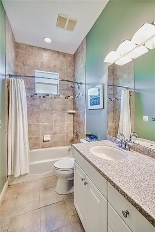 Laundry area with cabinet space, washing machine and dryer, and light tile patterned flooring