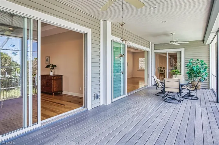 Wooden deck with a ceiling fan and outdoor dining area