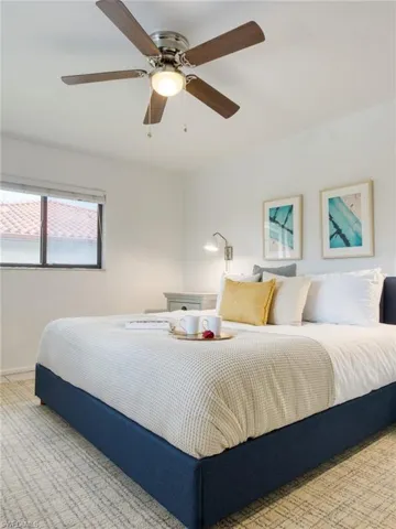 Carpeted bedroom with a ceiling fan