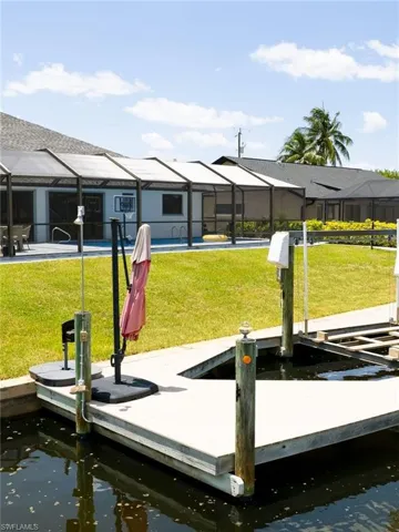 Dock area with a sunroom, a yard, and glass enclosure