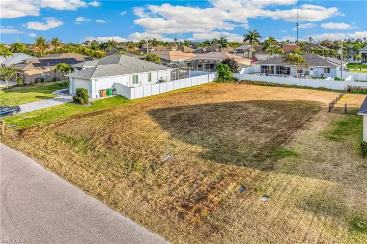 View of yard featuring a garage, a residential view, and driveway