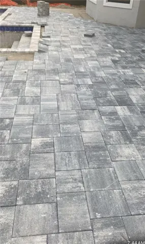Glacier color pavers in screened-in lanai with pool & spa