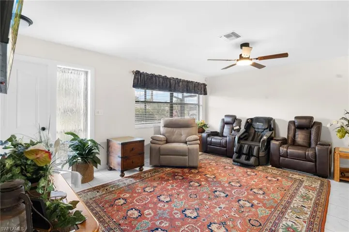 White tile flooring, ceiling fan with integrated lighting, and window with horizontal blinds