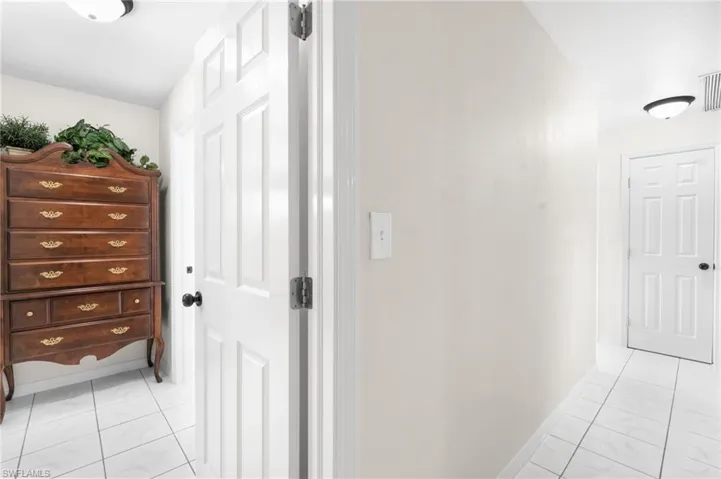 White paneled doors, white-painted walls, and white tiled flooring